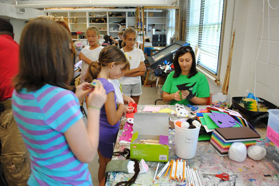 Teaching artist Celeste Aguzzi (seated) helps children make puppets at the 2011 Janice Wyatt Mississippi Summer Arts Institute.